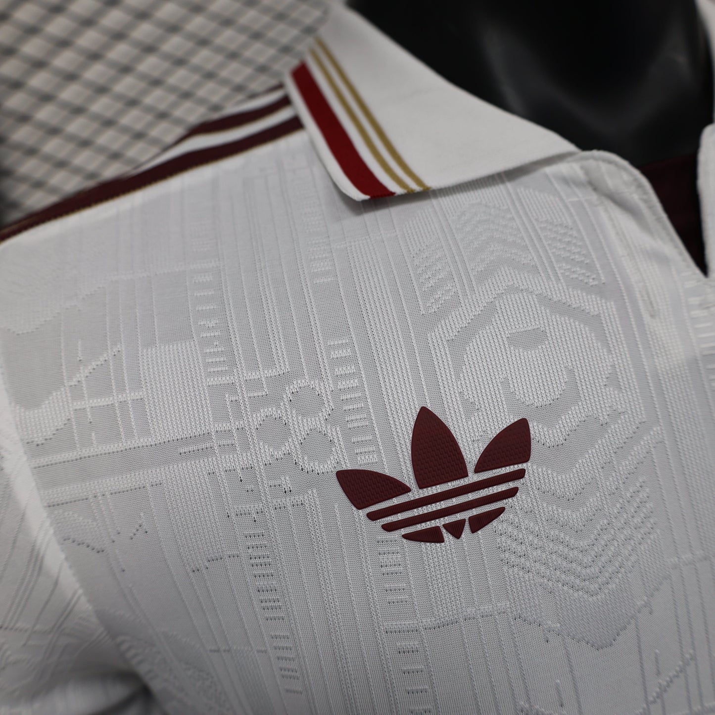 2025/26 Arsenal Away Player Version Jersey - White Body All-Over Tonal Emirates Stadium Architectural Line Emboss Pattern Deep Maroon Polo Collar Multi-Stripe Gold Red White Trim -Arsenal Cannon Crest - Emirates Fly Better