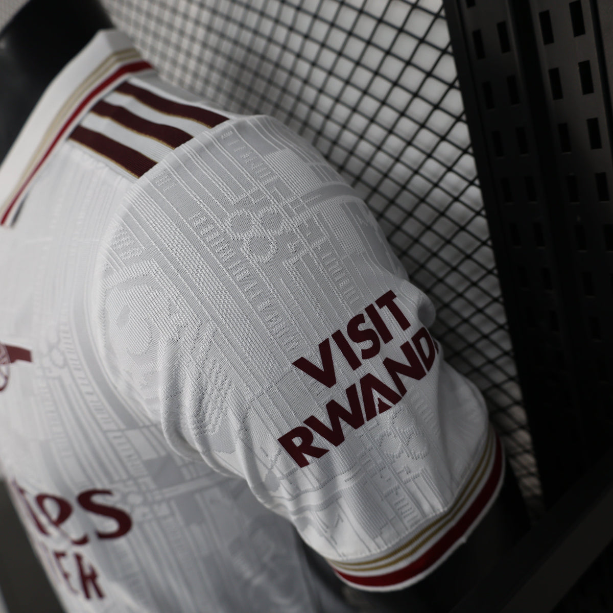 2025/26 Arsenal Away Player Version Jersey - White Body All-Over Tonal Emirates Stadium Architectural Line Emboss Pattern Deep Maroon Polo Collar Multi-Stripe Gold Red White Trim -Arsenal Cannon Crest - Emirates Fly Better